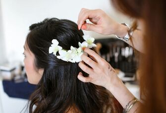 Hairstylist does bride's hair on her wedding day