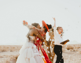 Couple kissing at the altar with officiant cheering for them