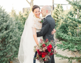 Couple sharing hug surrounded by Christmas trees