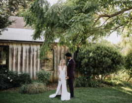 Couple standing in front of Park Winters barn wedding venue in Winters, California