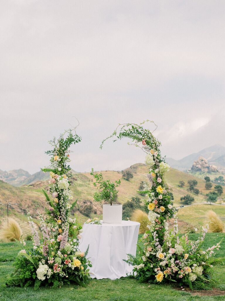 Ceremony altar with table and greenery arch with an opening at the top