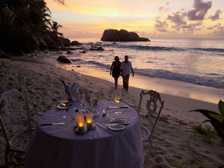 A couple enjoying a romantic beachside dinner together.