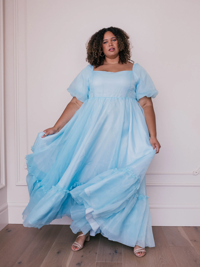 A model shows off this romantic and floaty light blue wedding guest dress.