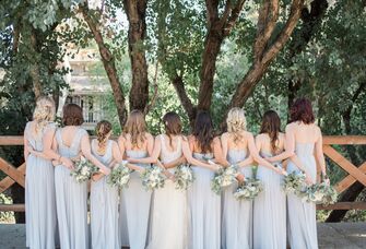 Bride and bridesmaids posing with their backs to the camera