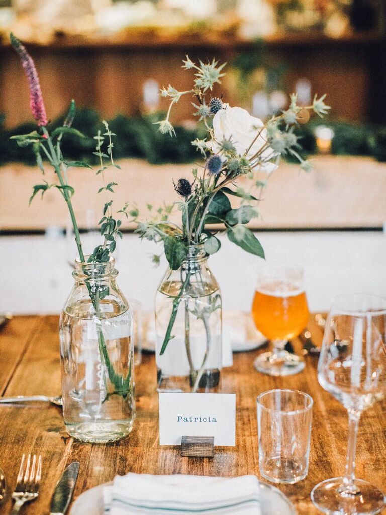 small rustic wedding centerpiece with flowers in glass milk bottles