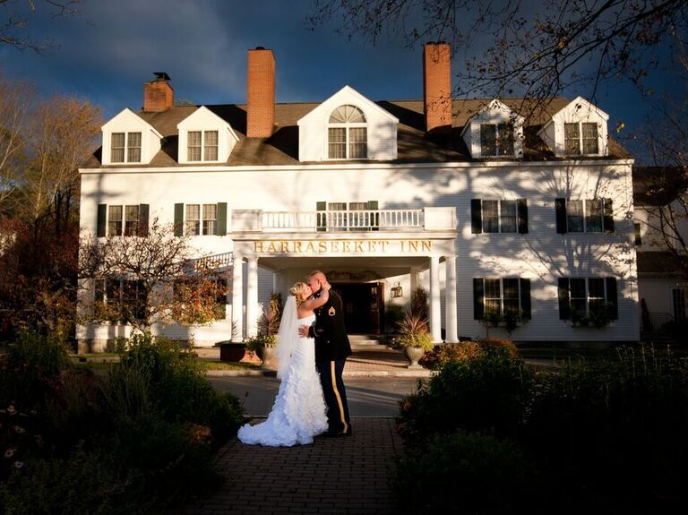 Couple kissing outside white mansion venue