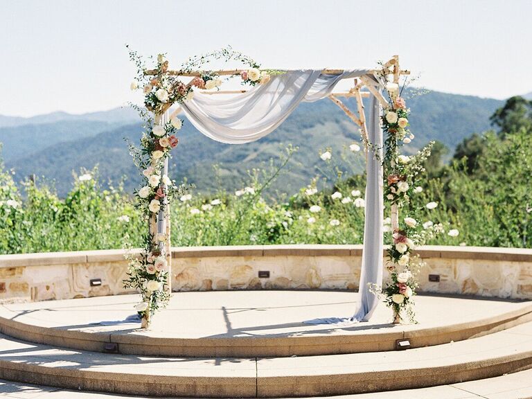 Rustic wood arch with linen draping