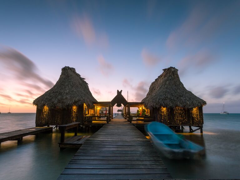 Overwater bungalow and jetty at sunset, Belize