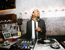 DJ smiling while playing music at a wedding.