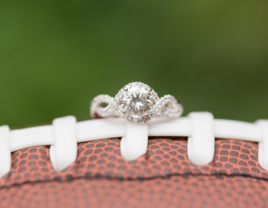 Engagement ring sitting on top of football 