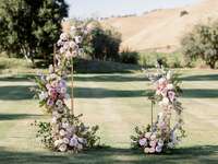 abstract wedding flower ceremony arch with pink and purple pastel flowers