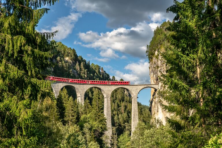 Electric red tourist train crossing Landwasser Viaduct