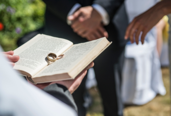 Two wedding rings rest on the Bible at a wedding