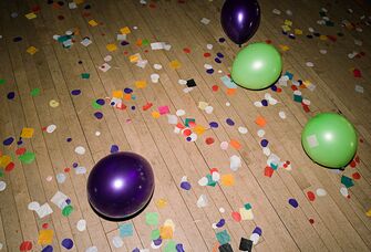 Balloons and confetti on the floor after a party ended