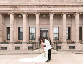 Happy newlyweds kissing in front of the beautiful venue