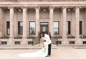 Happy newlyweds kissing in front of the beautiful venue
