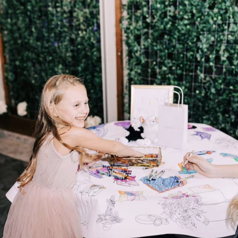 Young girl coloring on table cloth at wedding reception