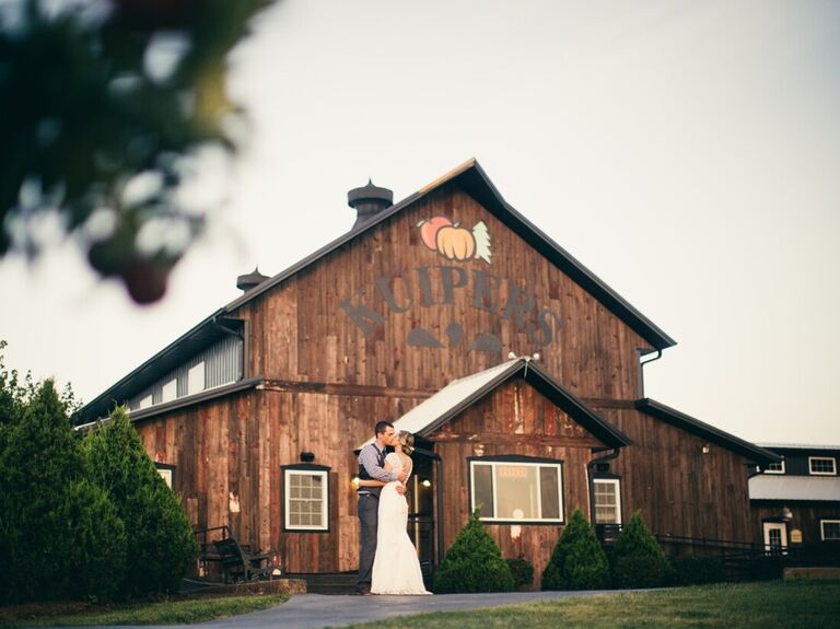 Couple kissing outside the barn venue