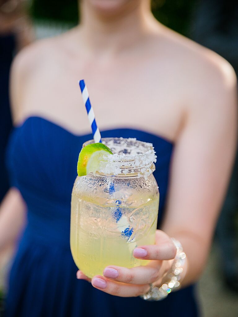 Mason jar margarita with a striped straw and salt rim
