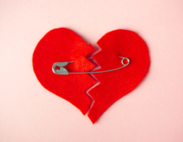 Broken heart held together by safety pin