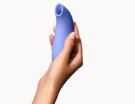 Person holding blue suction vibrator from Dame 