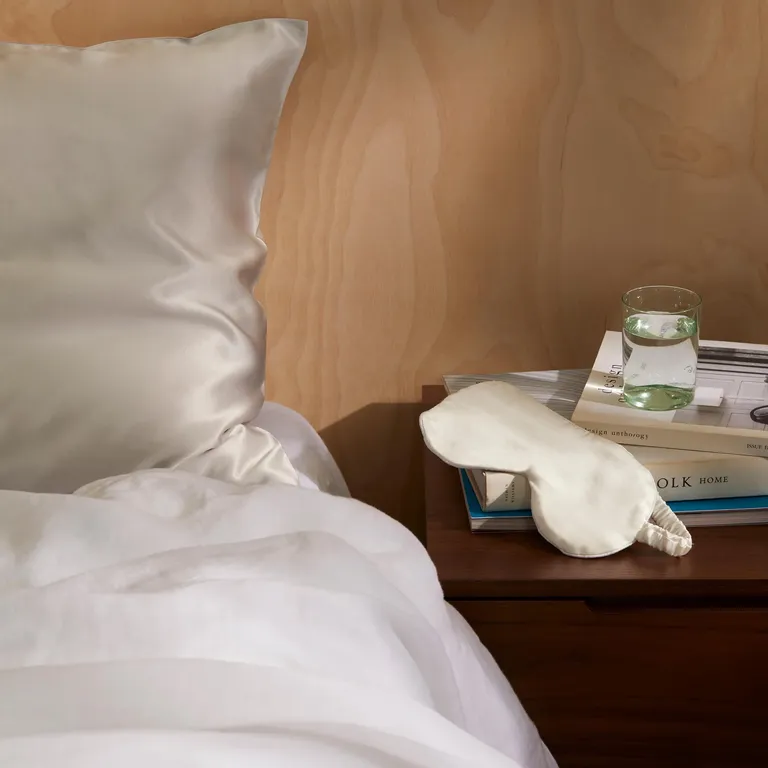 White silk eye mask on top of a pillow on a bed 12 year anniversary gift
