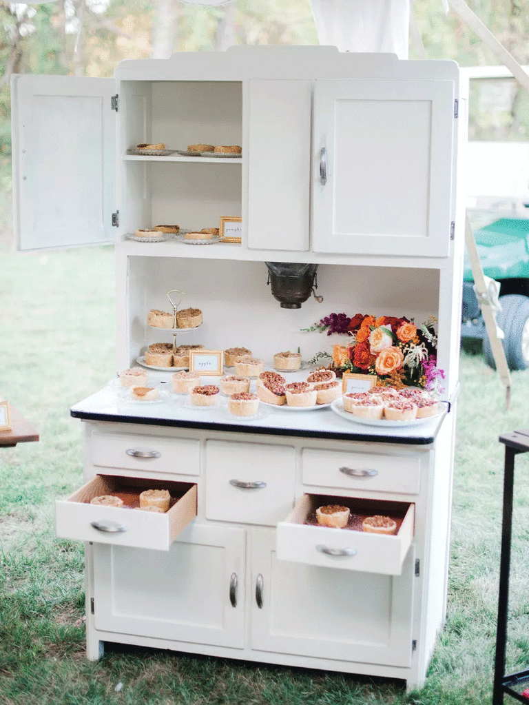 White cabinet used as pie display at DIY backyard wedding. 