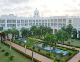 Aerial view of a white hotel with palm trees