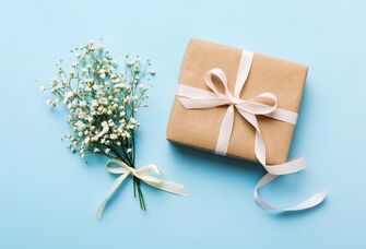 A wrapped wedding gift beside fresh florals