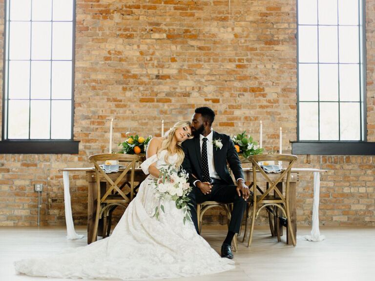 bride and groom with brick backdrop