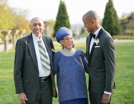 Groom poses with his parents, ultimate guide to father of the groom attire. 