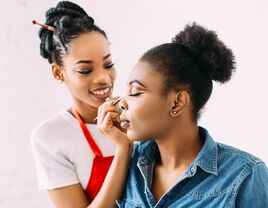 makeup artist applying makeup to woman