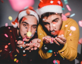 same sex couple blowing Christmas confetti