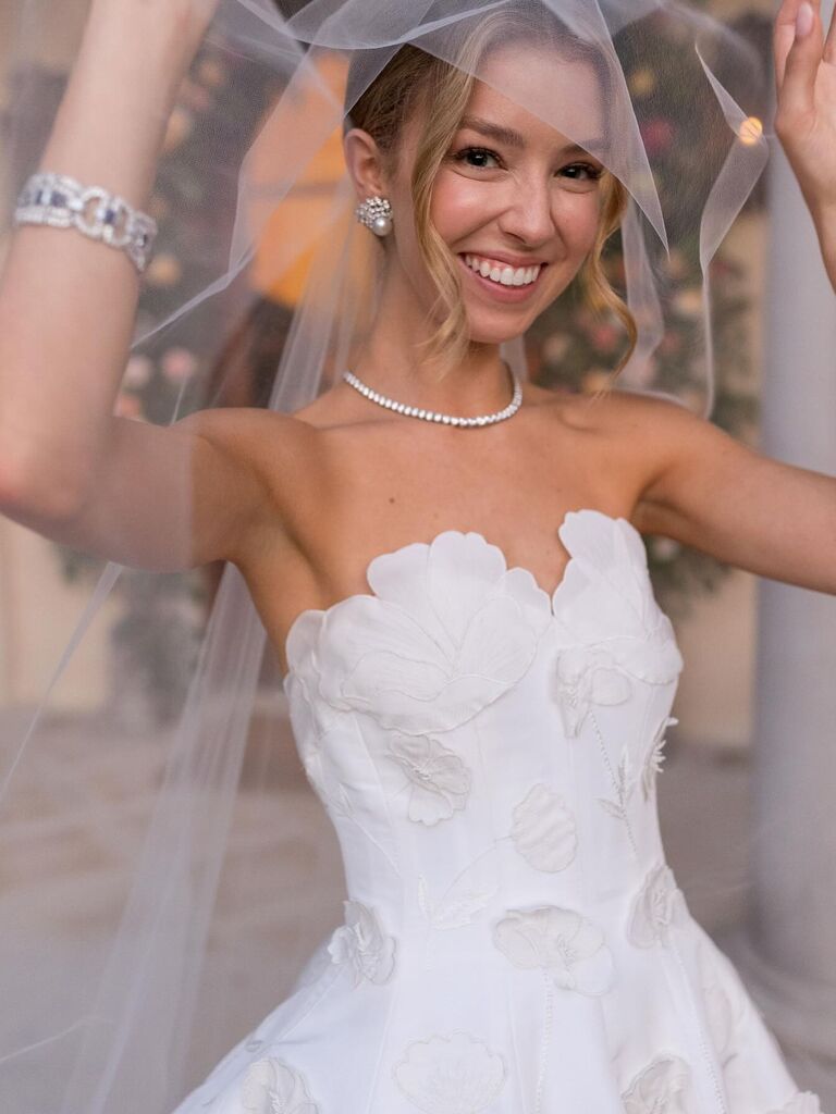 Bride lifting up her veil to show her beautiful face