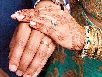 Bride with a diamond engagement ring and groom with wedding ring