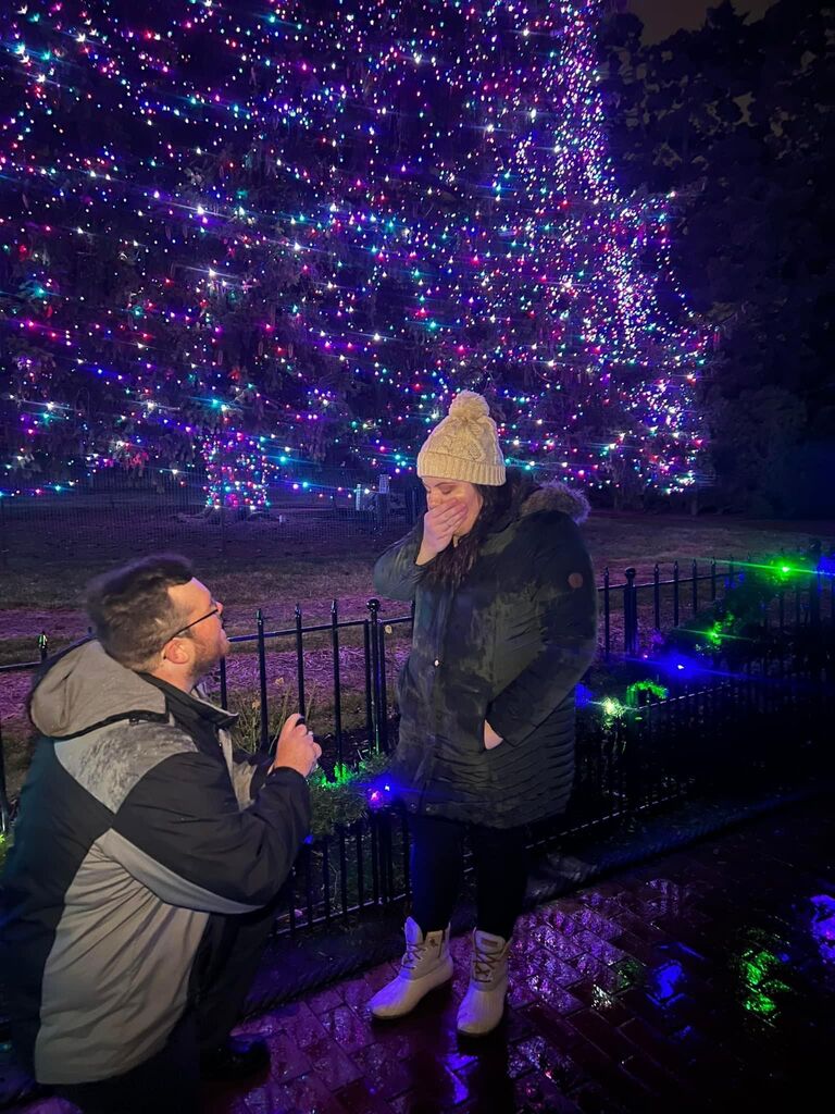 
Ryan was devising a plan. He had Kayla and her boyfriend ask to come see the zoo lights with them. Taryn naturally said yes, and it just so worked out Taryn's best friend was coming the day prior and stayed for the lights as well. There were many clues looking back on it now, but Taryn had no idea. Once they were in the zoo they started looking for any animals that may be out and taking photos all along the way. This was not out of the ordinary as Kayla is the *Selfie Queen*. They made their way toward the big tree and Taryn and Ryan were getting their photo taken. Little did Taryn know, but Ryan had the ring in his pocket ready to ask the question. He looked at her and said, "I have an important question to ask you." Taryn looked at him and he got down on one knee and popped the question! Taryn of course was in shock and asked, "Are you kidding?" Speechless for the first time in probably her whole life! She of course said, yes!
