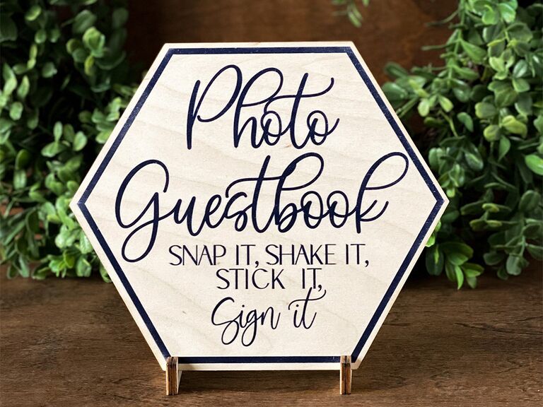'Photo guestbook' in loopy blue script on white birch hexagon sign