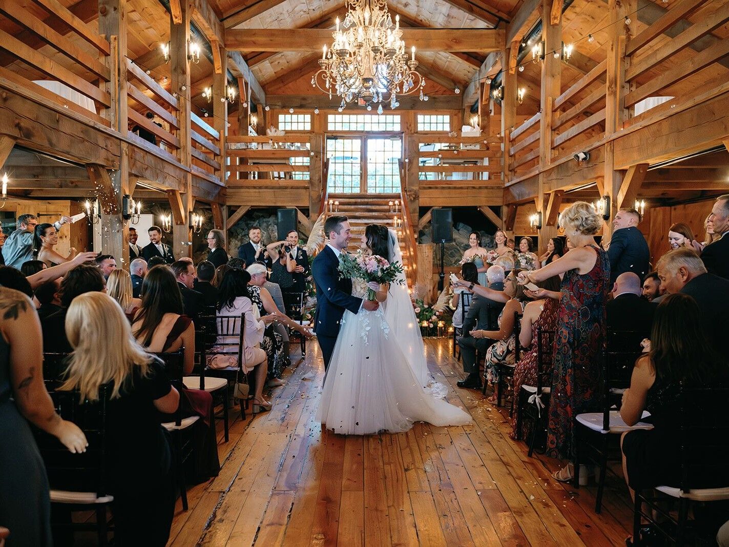 Couple celebrating in the middle of the aisle in the barn ceremony site