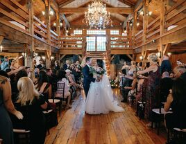 Couple celebrating in the middle of the aisle in the barn ceremony site