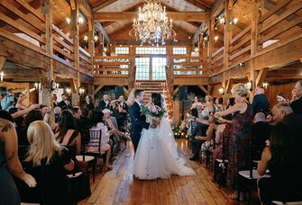 Couple celebrating in the middle of the aisle in the barn ceremony site