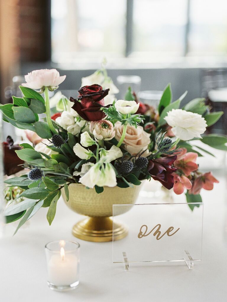 small wedding centerpiece with mauve and burgundy flowers in gold compote vase