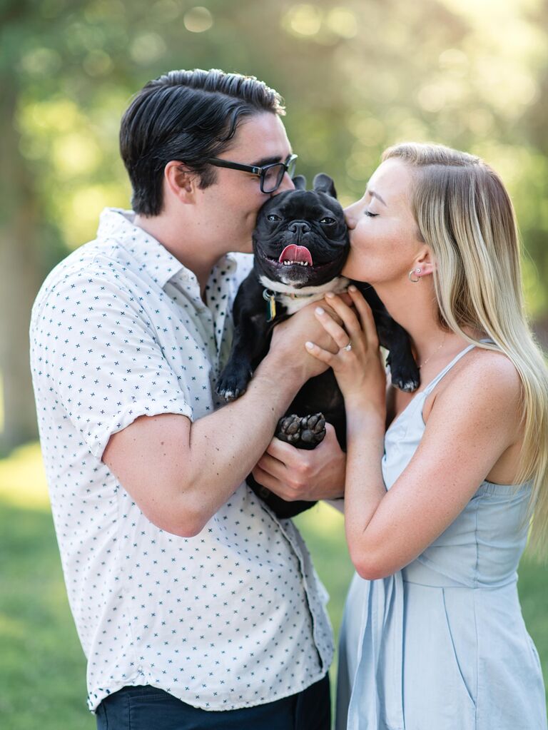 Couple kiss their dog during their engagement photo shoot. 