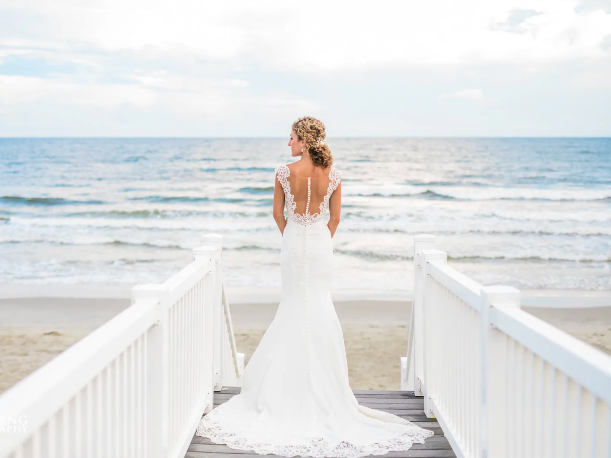 Bride standing in front of beach at Luxury Lodging by Laura North Carolina beach wedding venue