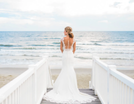 Bride standing in front of beach at Luxury Lodging by Laura North Carolina beach wedding venue