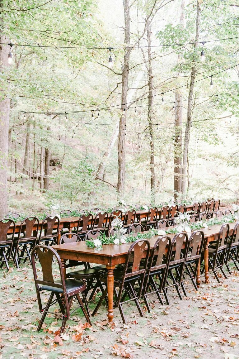 Long wood table with wood chairs situated in the woods