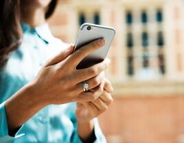 Woman holding phone with an engagement ring on 