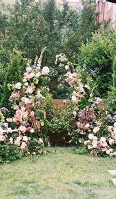 Composition florale pastel fantaisiste autour de l'autel de la cérémonie de mariage en extérieur