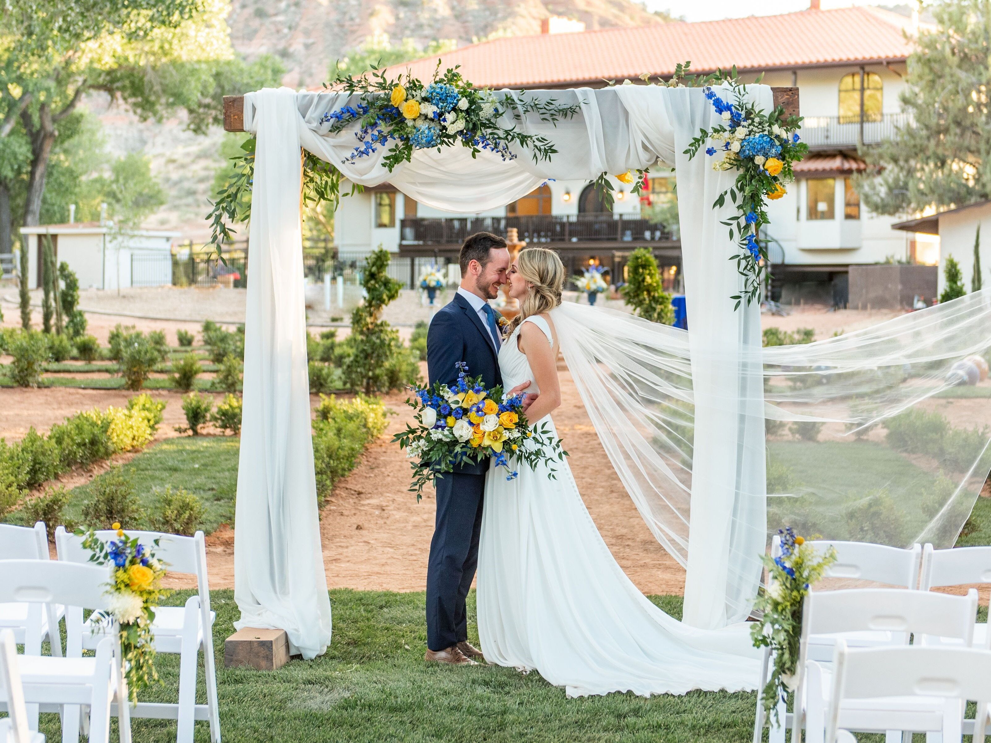 Romantic couple portrait underneath the decorated arch outside in the property's garden