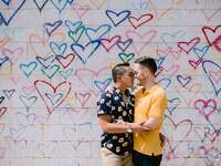 Couple hugging in front of wall mural