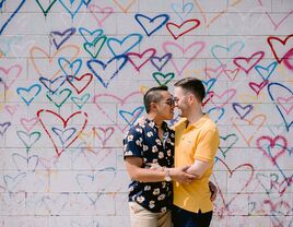 Couple hugging in front of wall mural